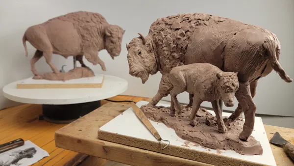 Clay scuptures of a calf, a cow and a bull bison.