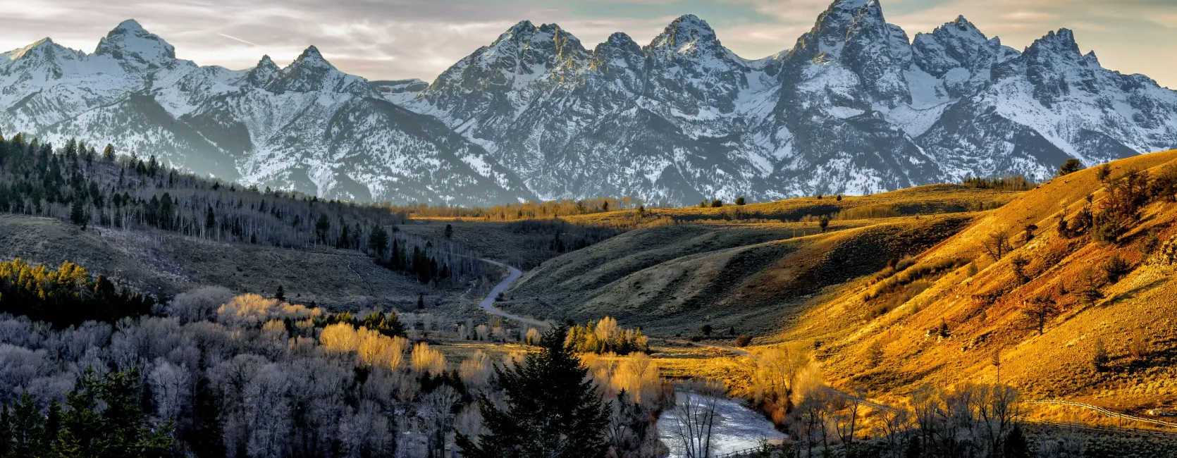 photo of a landscape with a river and snow-capped mountains