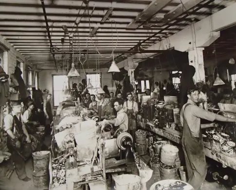 Black and white historic photo of people working in a button factory