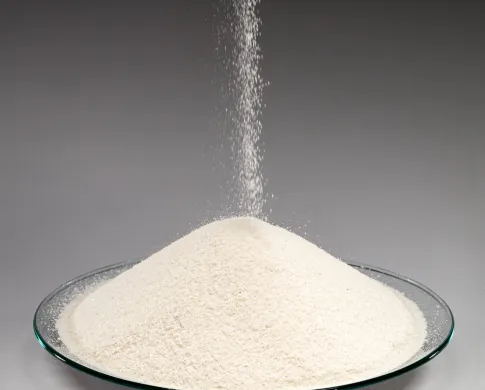 Photo of grains of sand falling and collecting on a clear dish